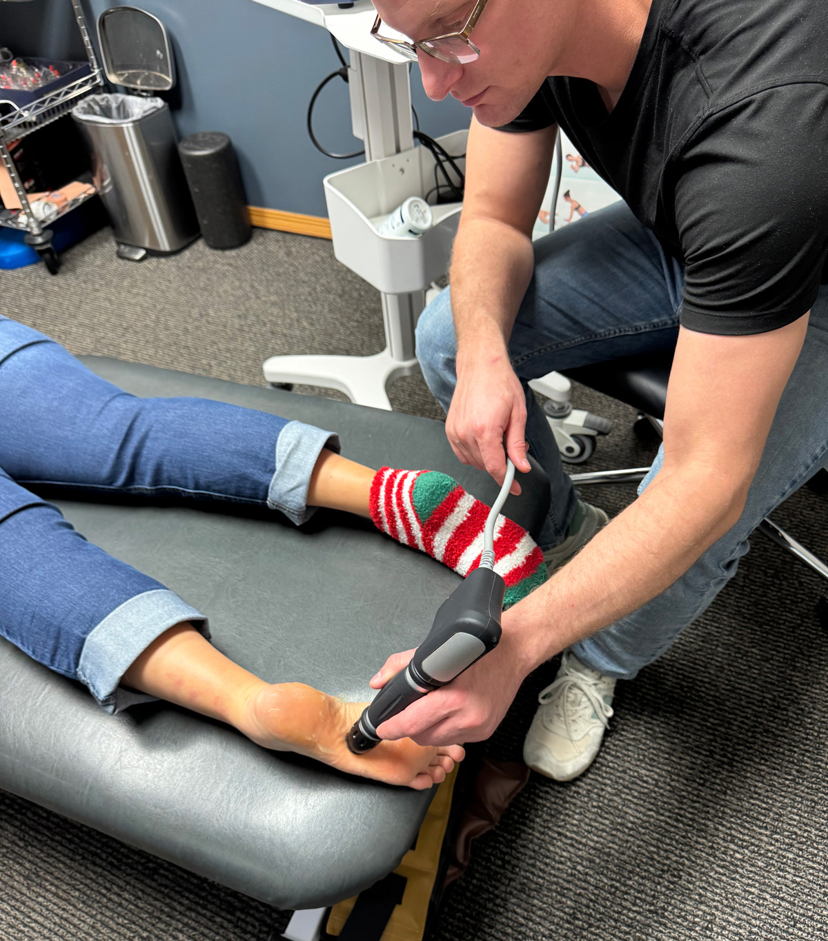 dr keith sparks using shockwave therapy on a patient's foot