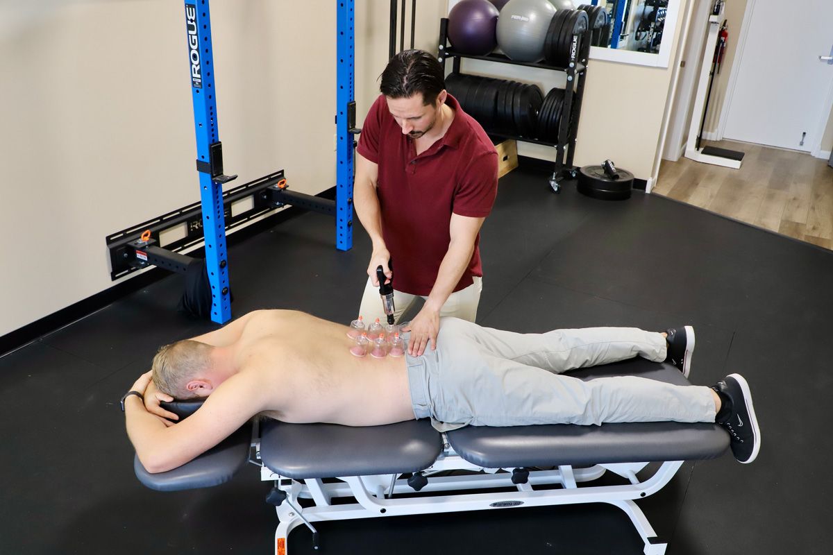 chiropractor cupping a patient's lower back