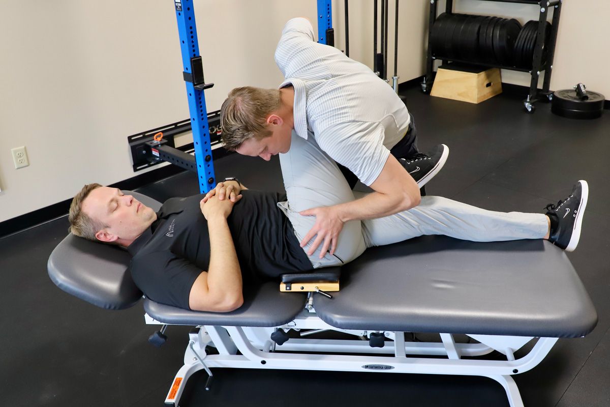 chiropractor adjusting hip and spine of chiropractic patient